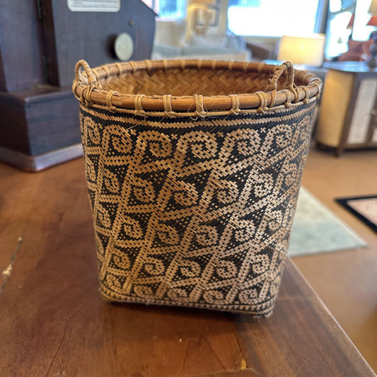 Woven basket with geometric pattern on a wooden surface