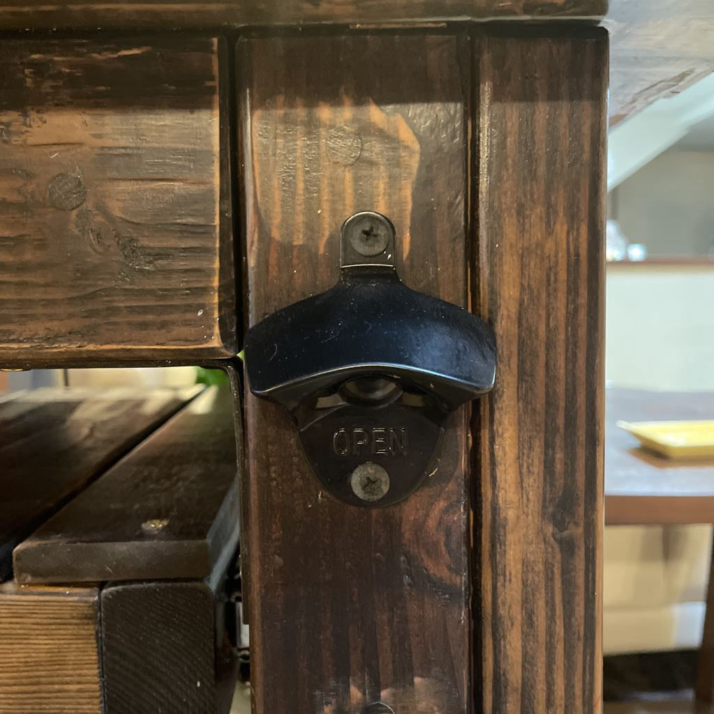 Wooden bottle opener attached to a wooden surface