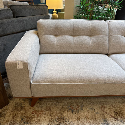 Beige sectional sofa in a room with a lamp and plants