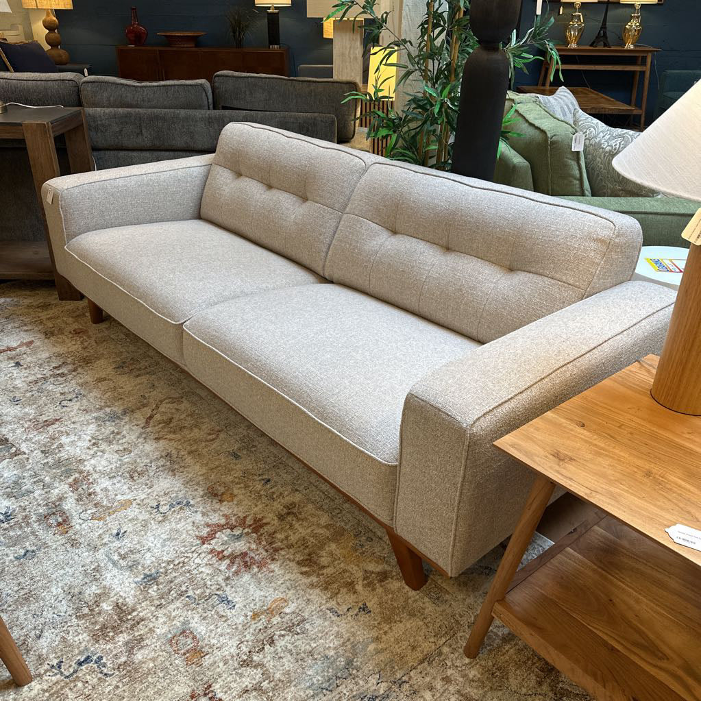 Beige sofa in a room with other furniture and decor