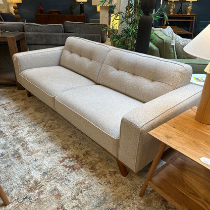 Beige sofa in a room with other furniture and decor