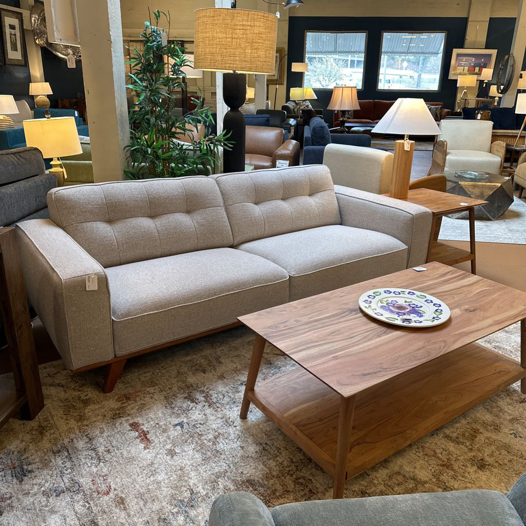 Beige sofa in a room with wooden coffee table and decorative items