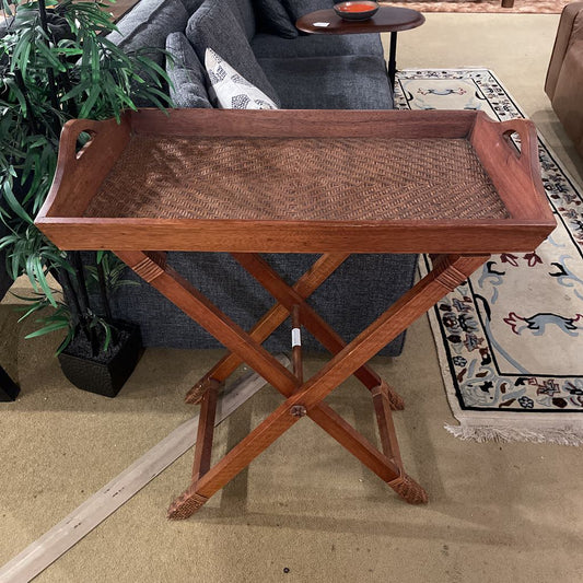 Wooden tray table with woven surface in a living room setting