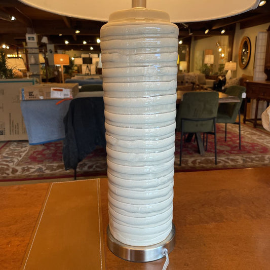 Decorative lamp with ribbed design on a wooden surface in a store setting
