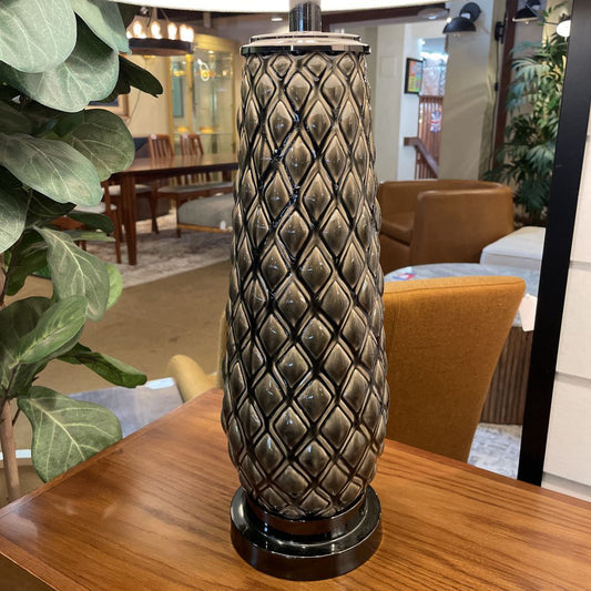 Decorative vase on a wooden table with a room interior in the background