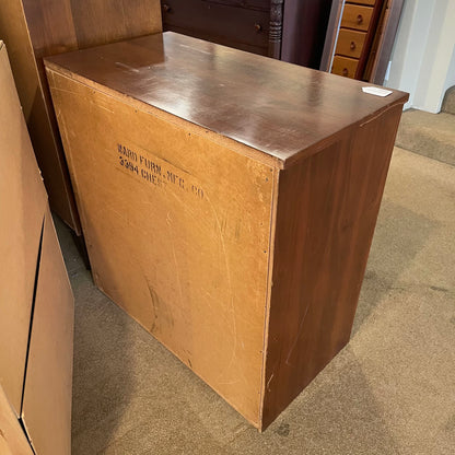 Large cardboard box on a carpeted floor with furniture in the background
