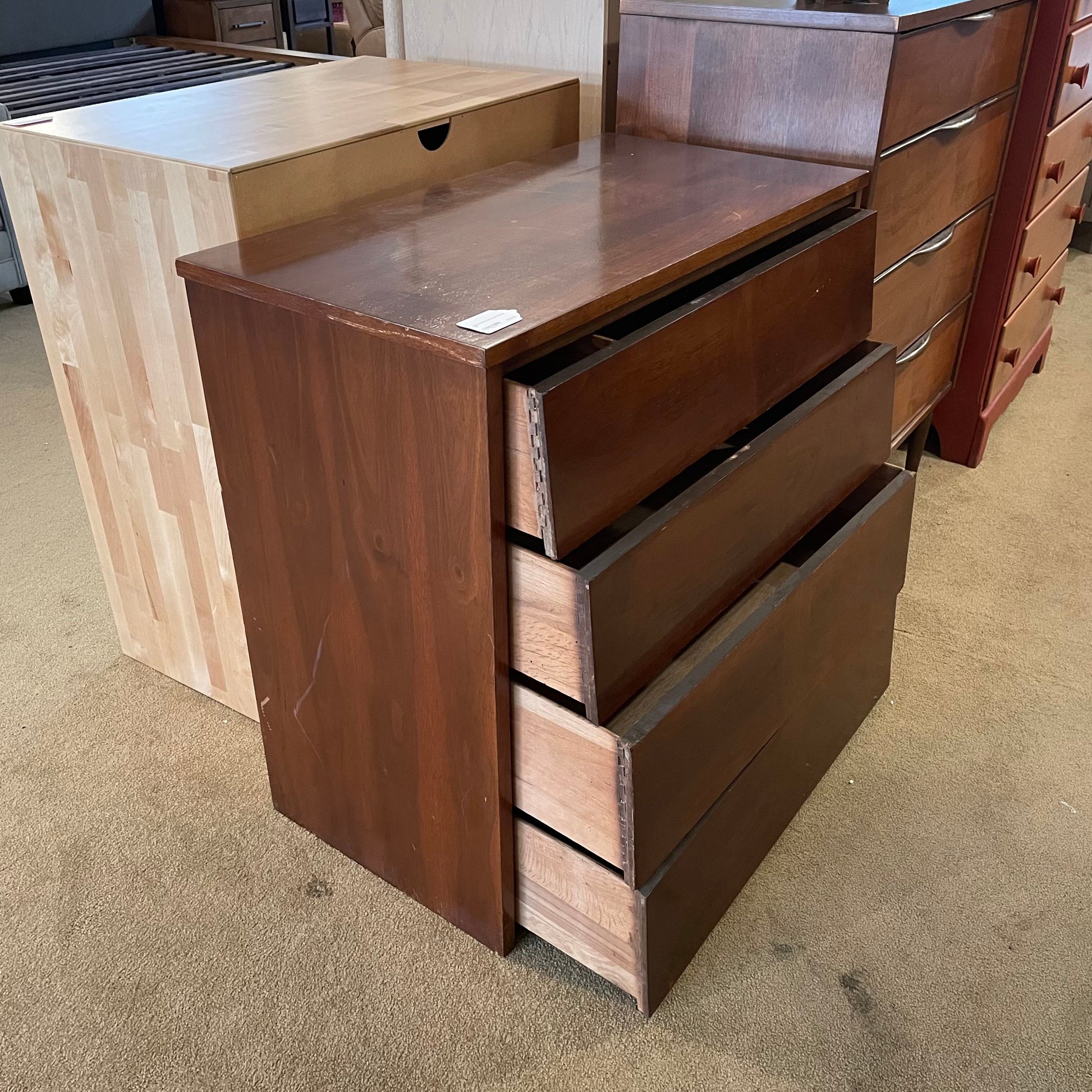 Wooden dresser with multiple drawers on a carpeted floor