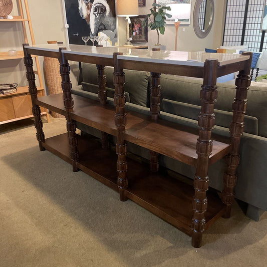 Wooden console table with shelves in a living room setting