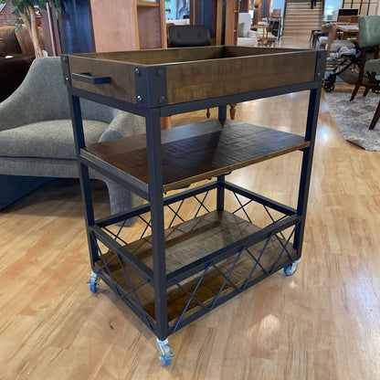 Metal serving cart with wooden top on a wooden floor