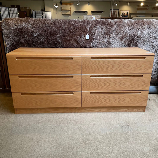 Wooden dresser with four drawers in a store setting