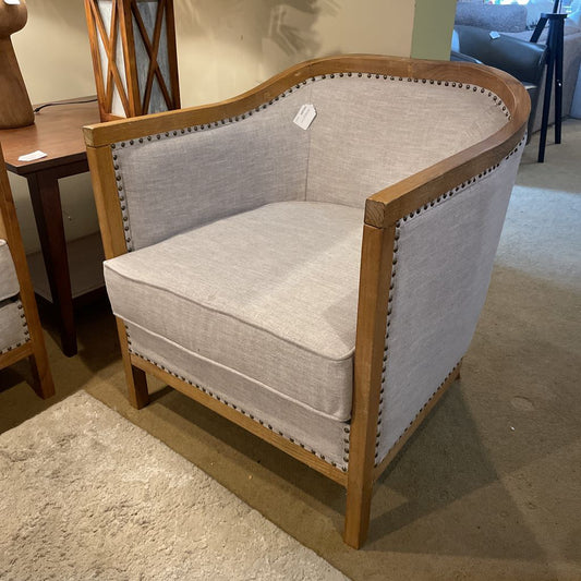Chair with wooden frame and gray cushion in a room setting