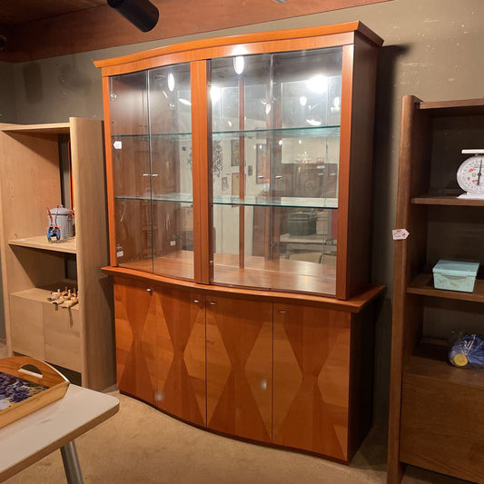 Wooden display cabinet with glass doors in a room setting