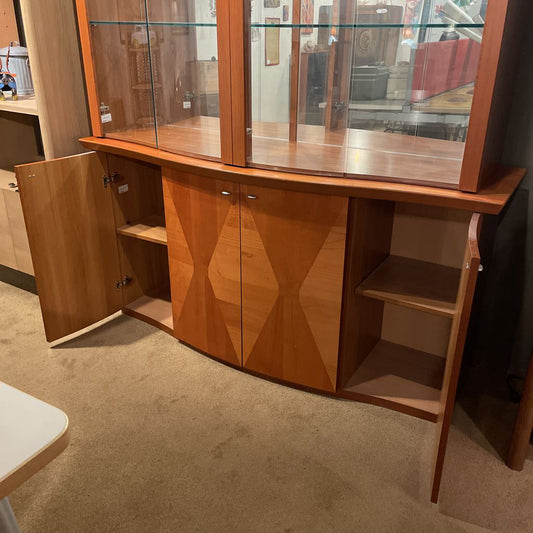 Wooden display cabinet with glass doors and geometric design on a carpeted floor.