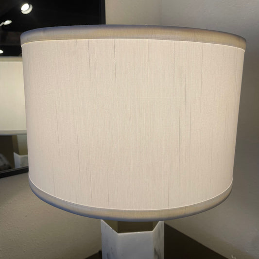 Beige lampshade on a stand against a neutral background