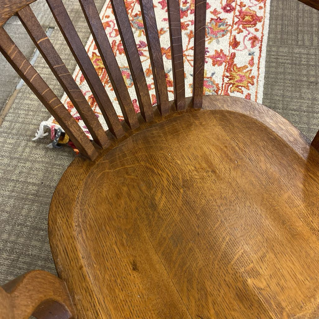 Wooden chair with a floral-patterned rug in the background