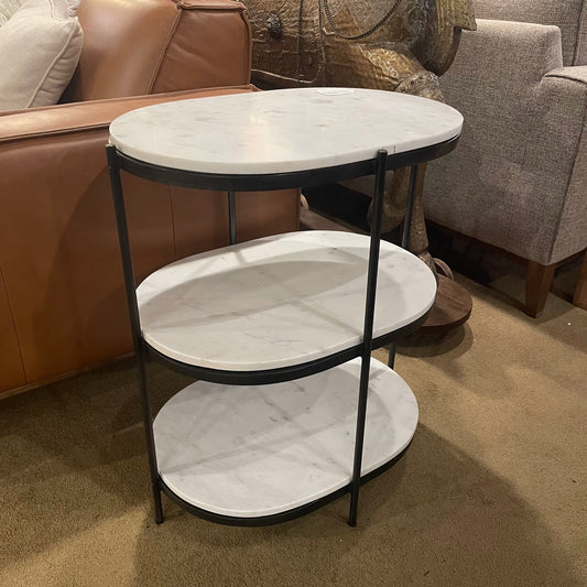Marble-patterned side table with black metal frame in a living room setting.