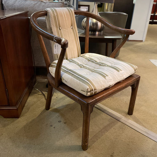Wooden chair with striped cushion in a showroom setting
