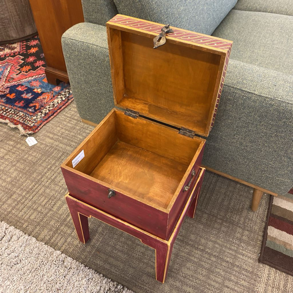 Wooden box with a hinged lid on a carpeted floor