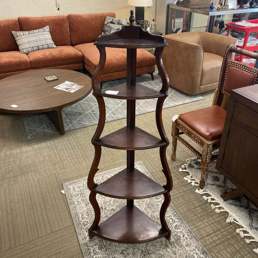 Wooden corner shelf in a living room setting with furniture and decor.