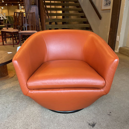 Orange leather chair in a room with furniture and stairs
