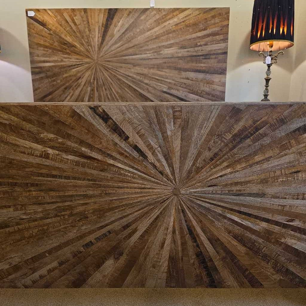 Wooden wall art with starburst pattern on a plain background