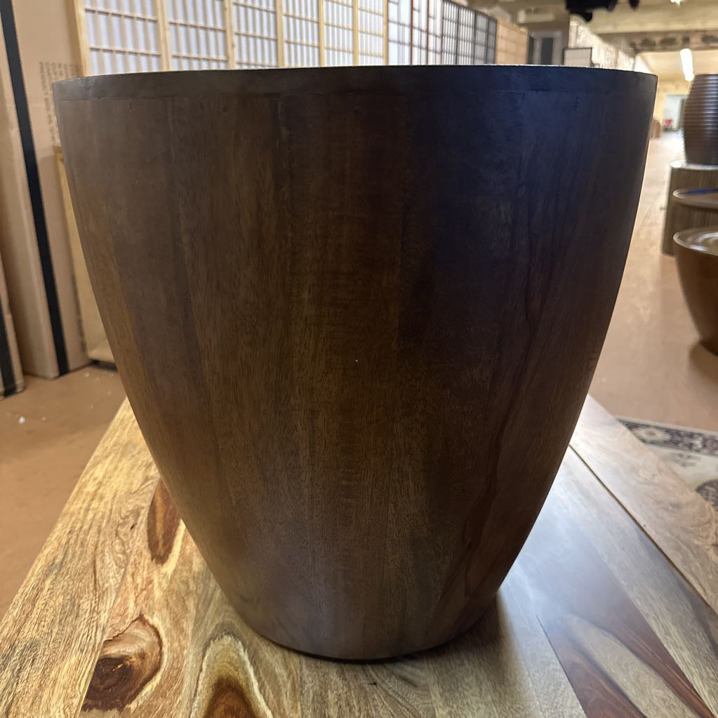 Wooden side table with textured surface on a carpeted floor