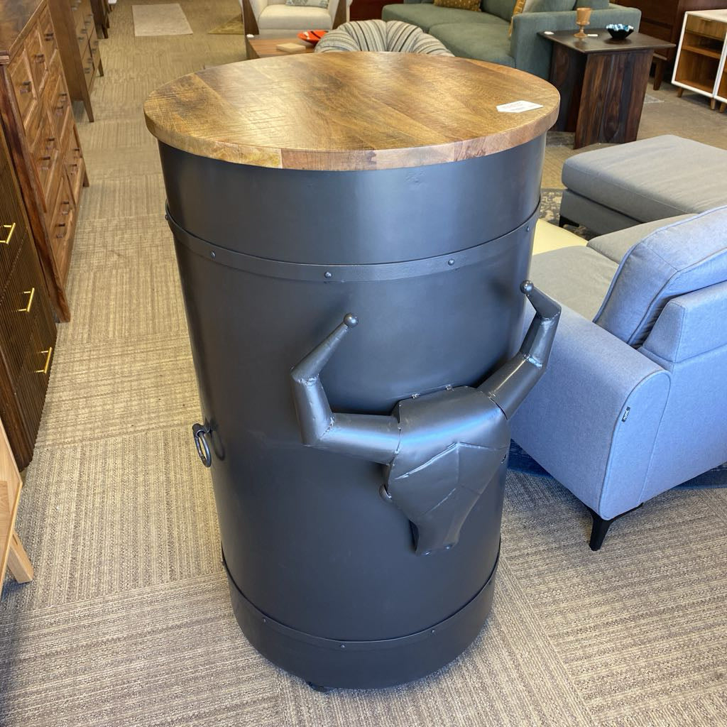 Wooden top cylindrical table with metal base in a furniture store setting