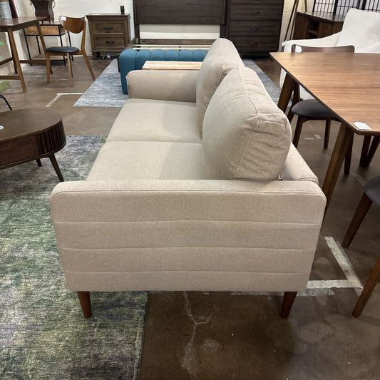 Beige sofa in a room with furniture and decor