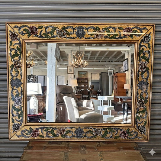 Decorative mirror with ornate gold frame in a room setting