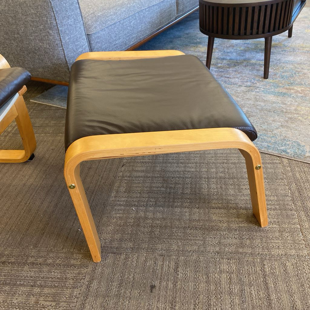 Wooden stool with black cushion on a carpeted floor