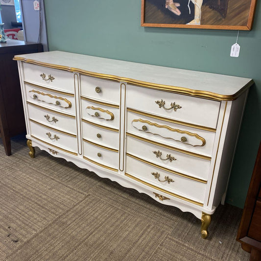 White dresser with gold accents in a room setting