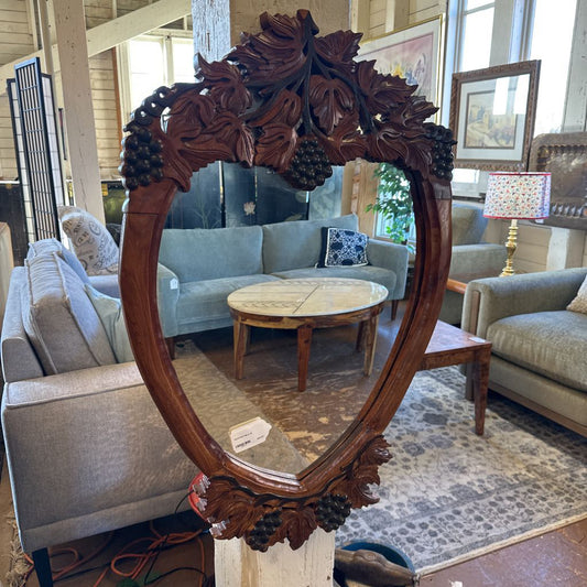 Decorative wooden mirror with intricate carvings in a living room setting