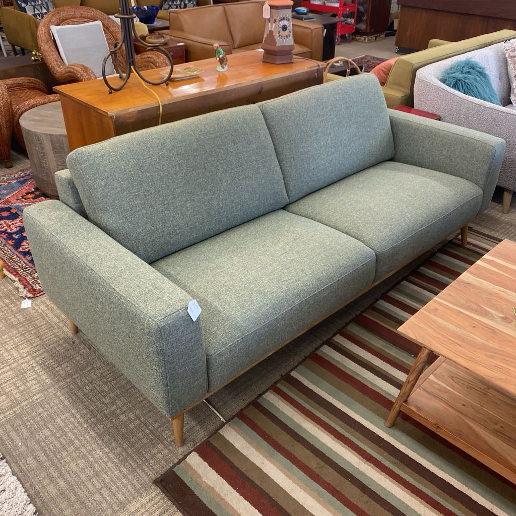 Green sofa in a room with furniture and decor