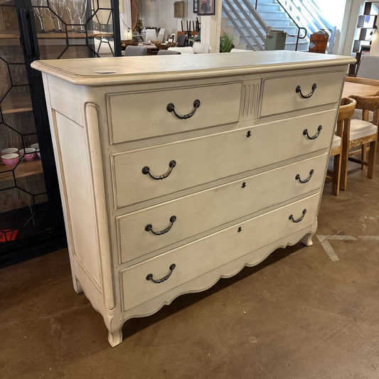 Beige dresser with multiple drawers in a room setting