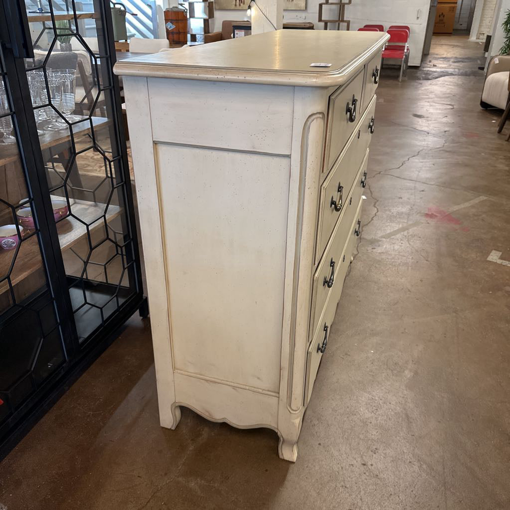 White dresser with multiple drawers in a room setting