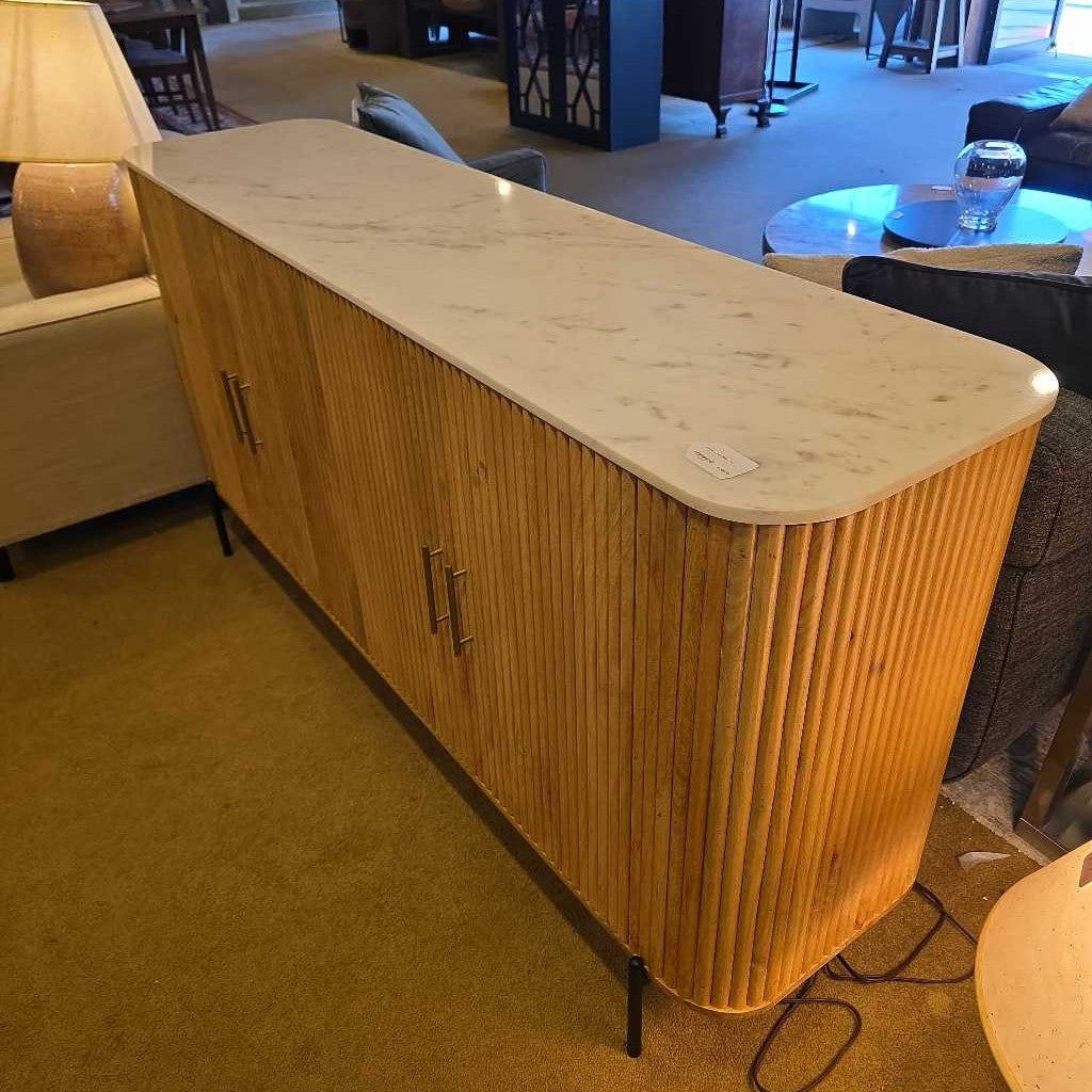 Wooden sideboard with marble top in a room setting