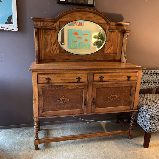 Wooden sideboard with decorative mirror against a wall