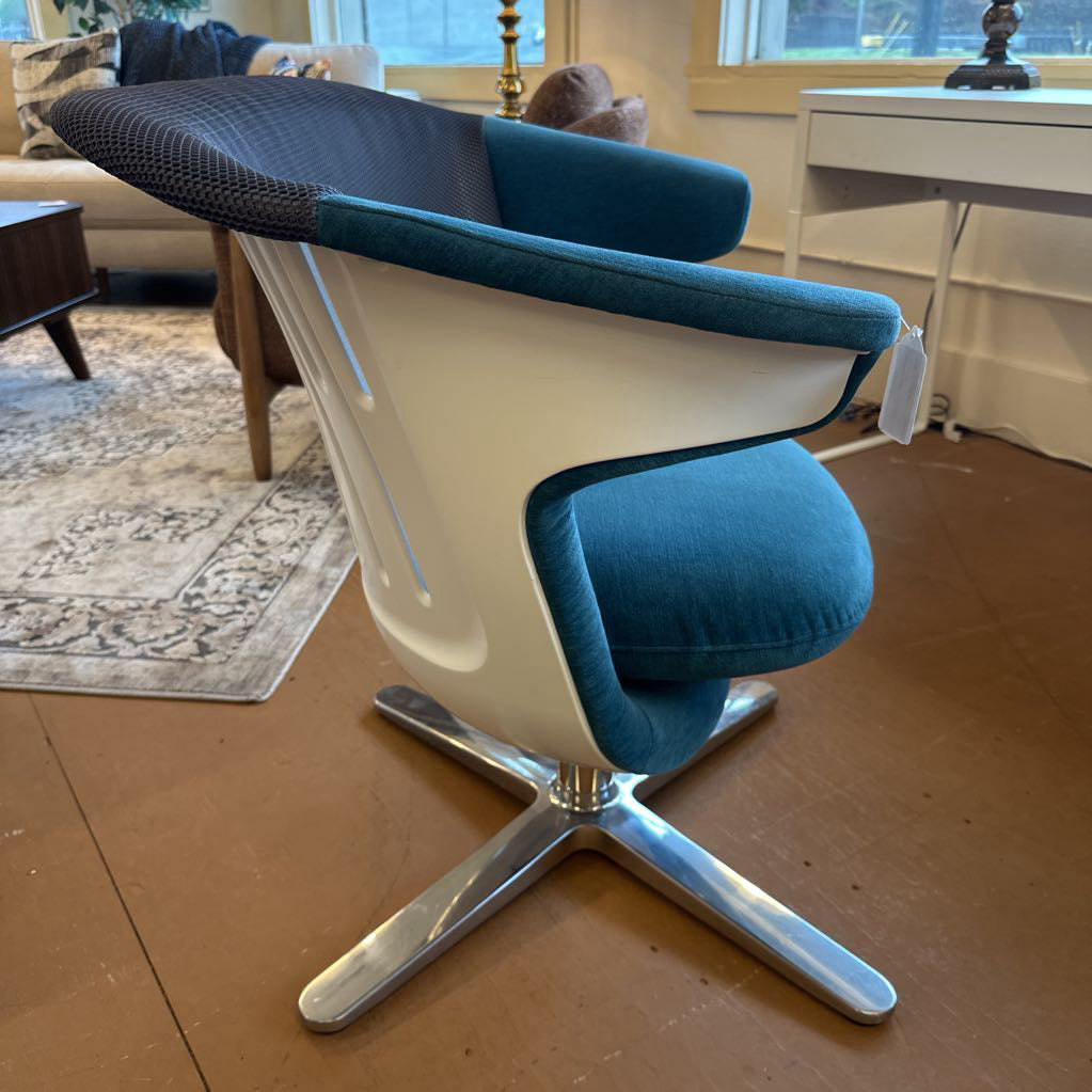 Modern blue and white chair with a metal base in a living room setting.