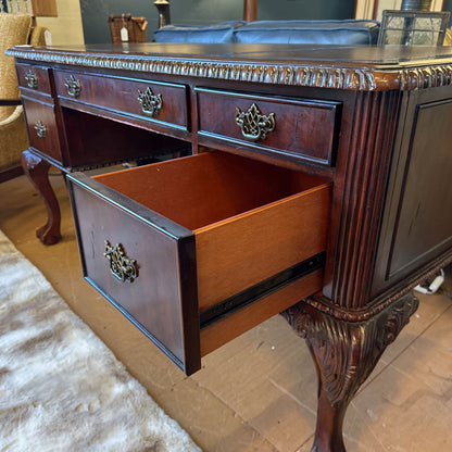 Wooden desk with an open drawer in a room setting