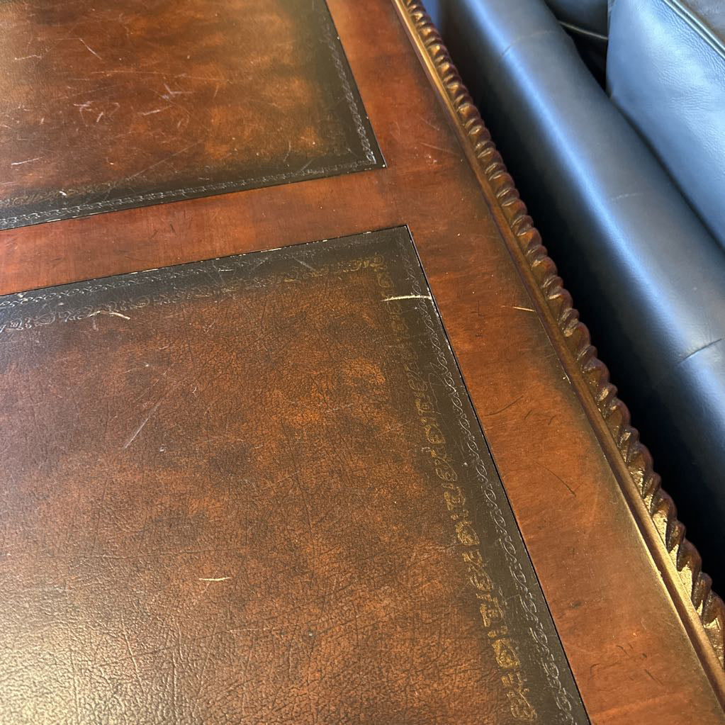 Close-up of a wooden surface with a decorative edge, possibly part of a furniture piece.