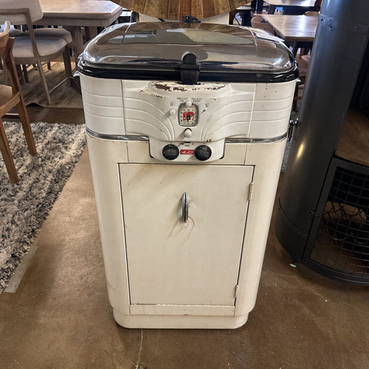 Vintage-style cooler with black lid in a casual indoor setting