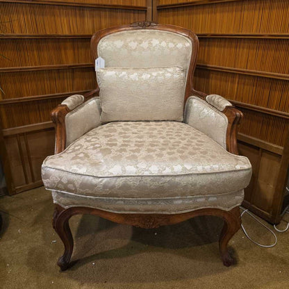 Vintage armchair with floral patterned upholstery in a room with wooden paneling.