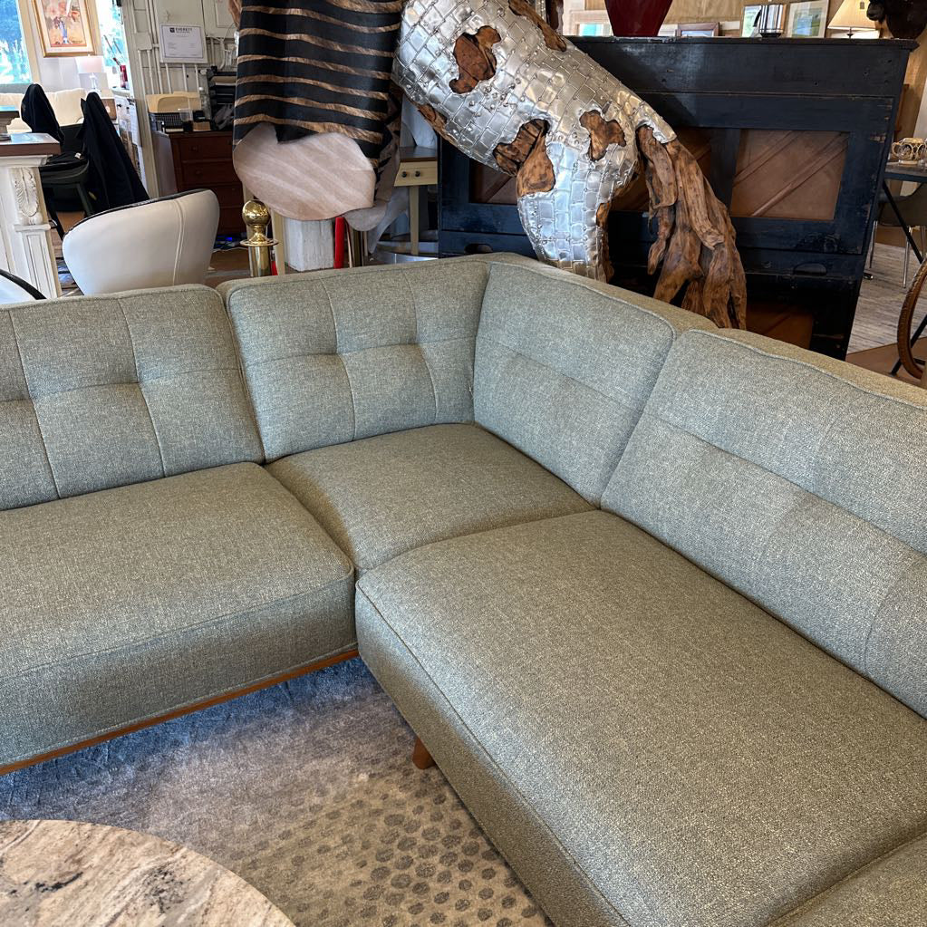 Gray sectional sofa in a room with decorative elements and furniture.