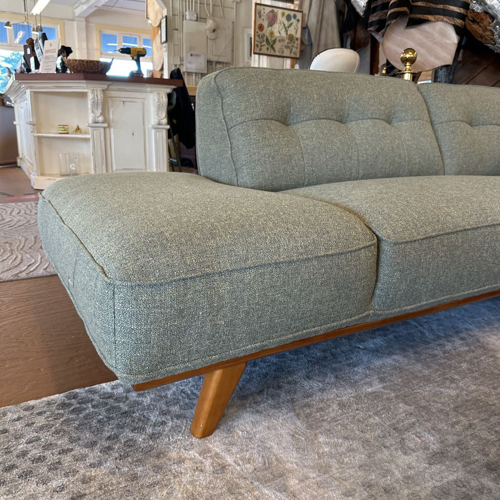 Gray sofa with wooden legs in a room setting