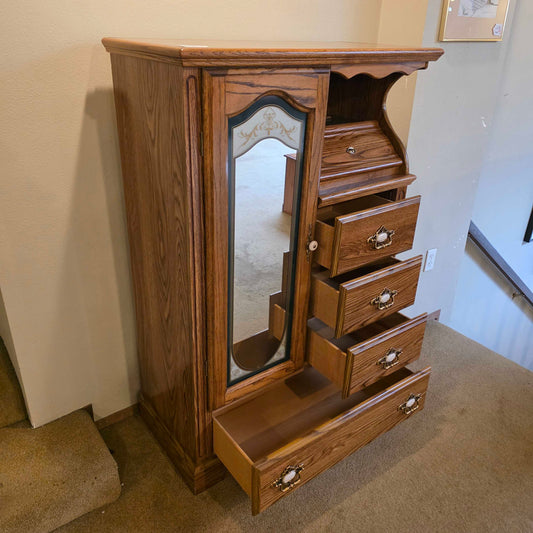 Wooden dresser with multiple drawers and a mirror in a room setting.