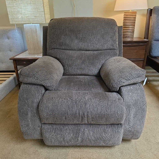 Gray recliner chair in a room with lamps and furniture.