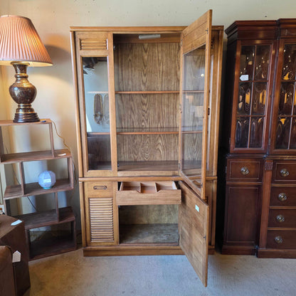 Wooden cabinet with open doors displaying glass shelves and interior compartments.