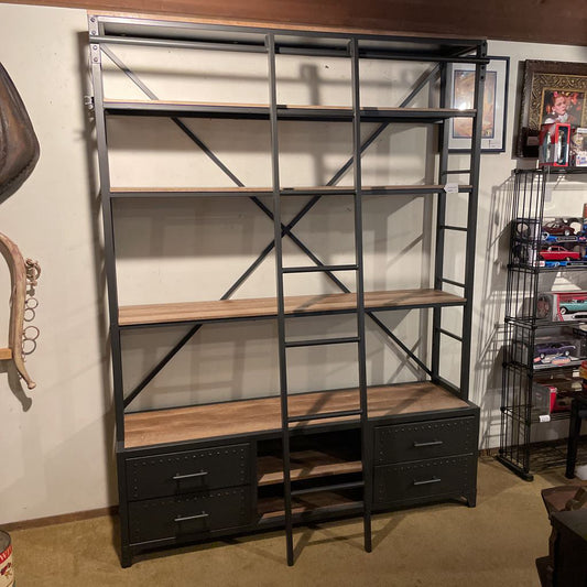 Industrial-style bookshelf with wooden shelves and metal accents in a room setting.