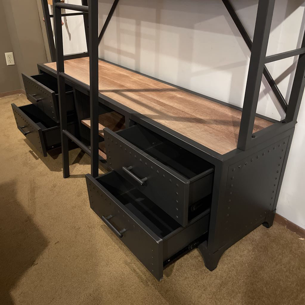 Black metal bunk bed with wooden top and multiple drawers in a room.