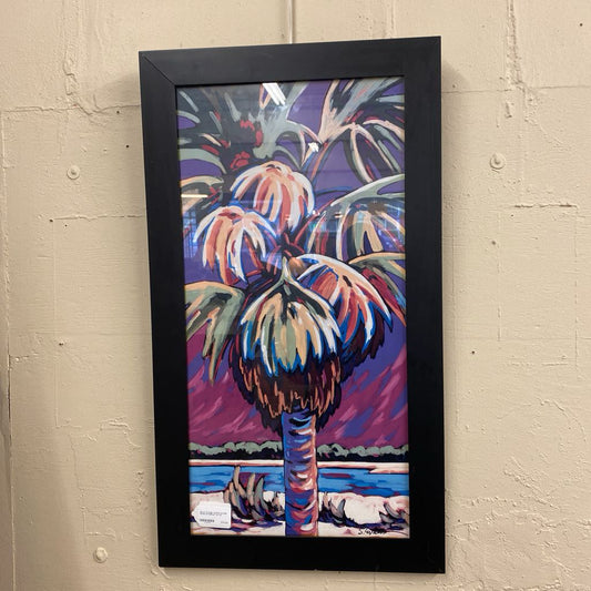 Framed artwork of a colorful palm tree on a beige wall